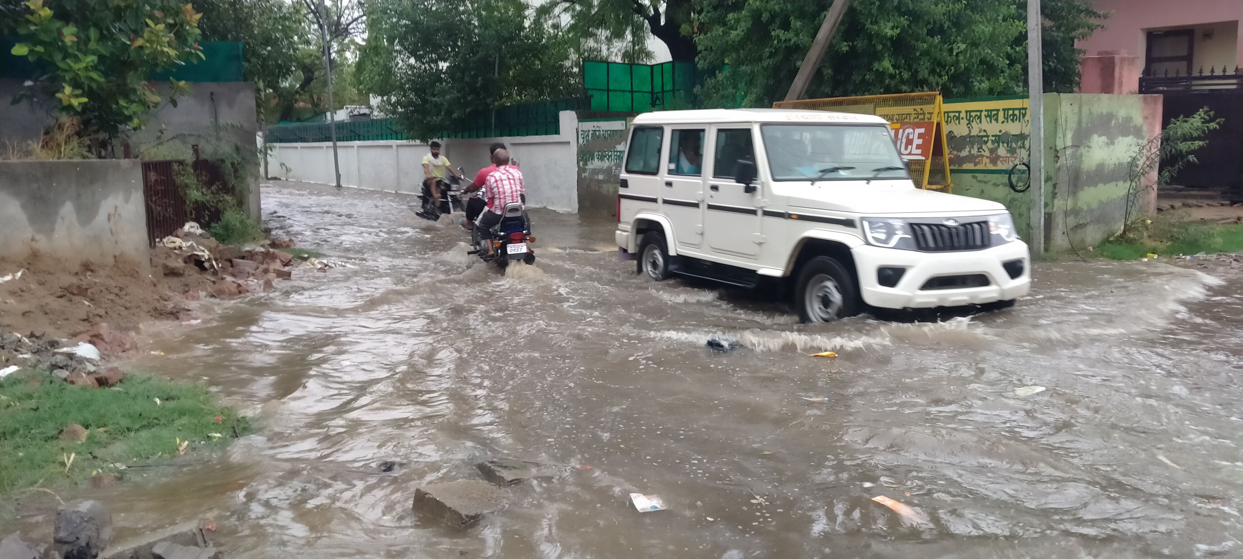 रेस्ट हाउस रोड पर भरे पानी से गुजरते वाहन। रेस्ट हाउस रोड पर भरे पानी से गुजरते वाहन।