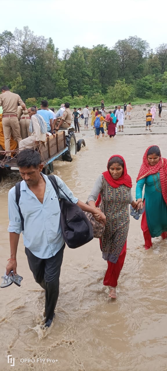 नदी के पानी से होकर माता के दर्शनों को जाते श्रद्वालु नदी के पानी से होकर माता के दर्शनों को जाते श्रद्वालु