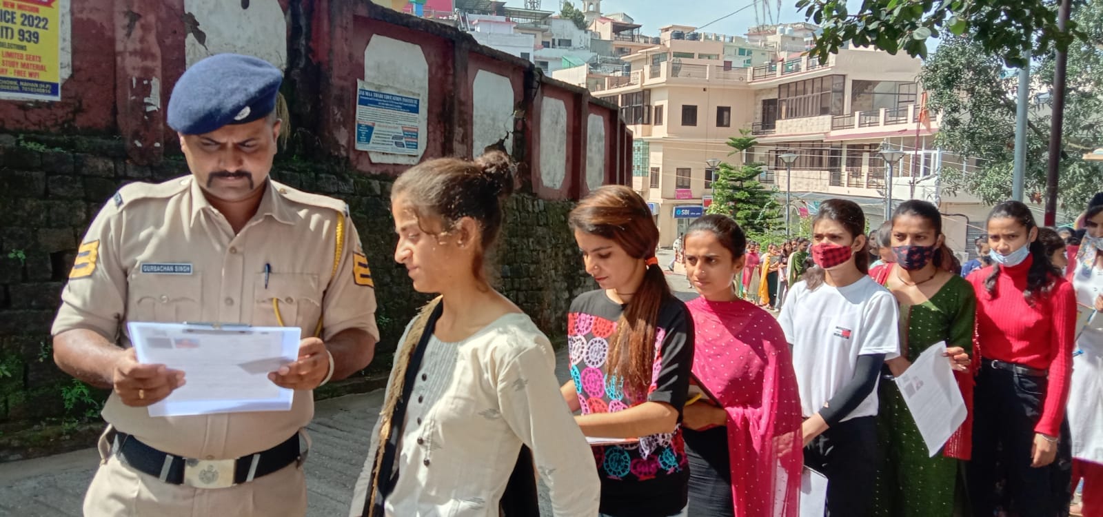 परीक्षा केंद्र पर अभ्यर्थी के एडमिट कार्ड की जांच करता पुलिस कर्मी। संवाद