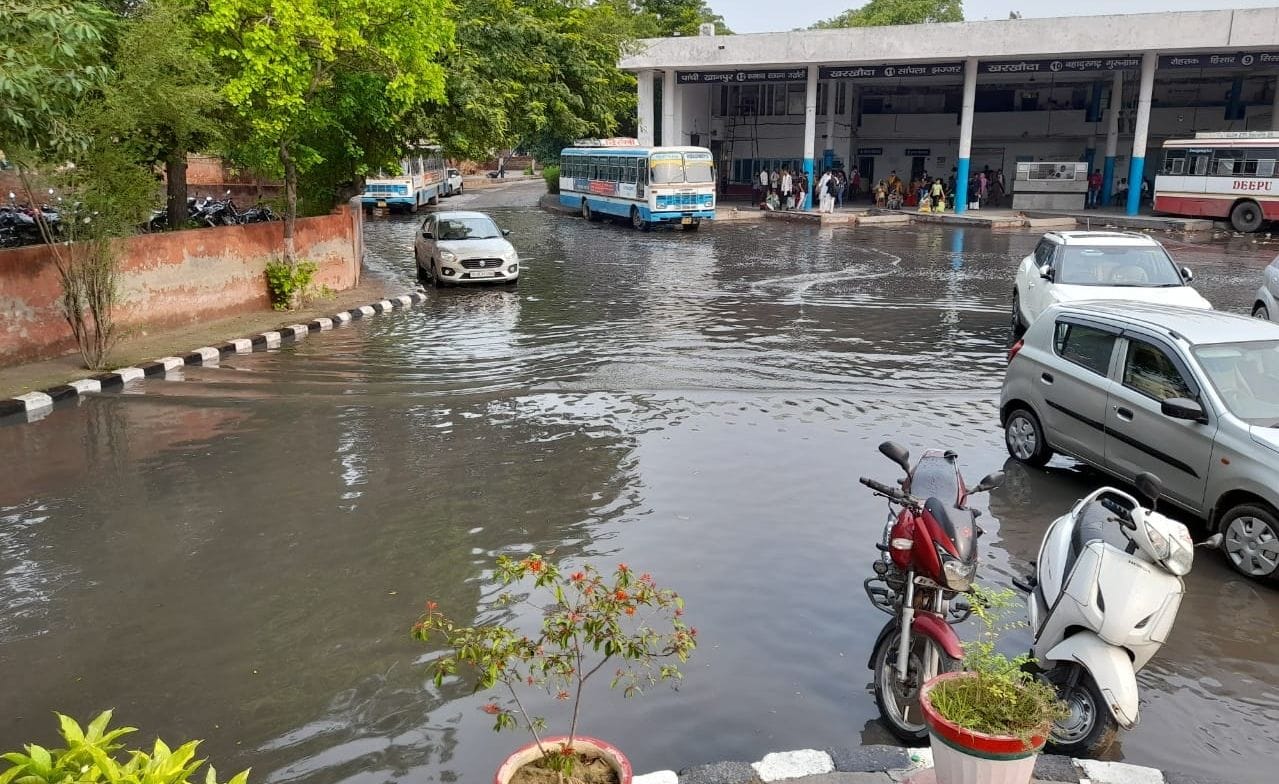 ड्रेन नंबर-6 के ओवरफ्लो होने के कारण बस अड्डे में भरा दूषित पानी। संवाद