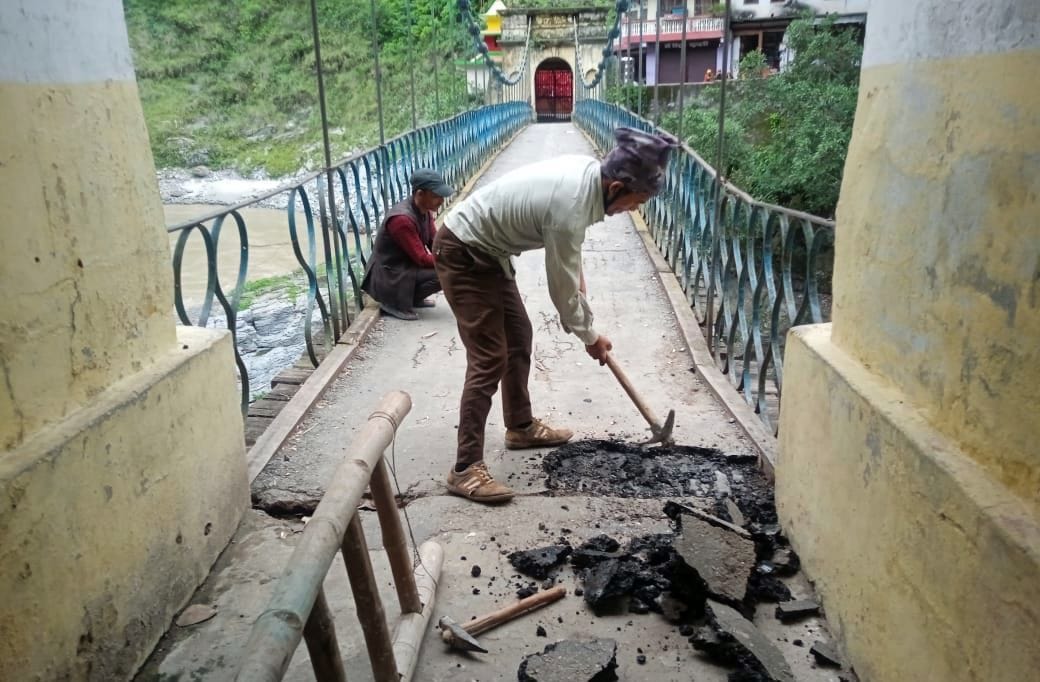 झूलाघाट में भारत और नेपाल को जोड़ने वाले पुल की मरम्मत करते मजदूर। संवाद न्यूज एजेंसी