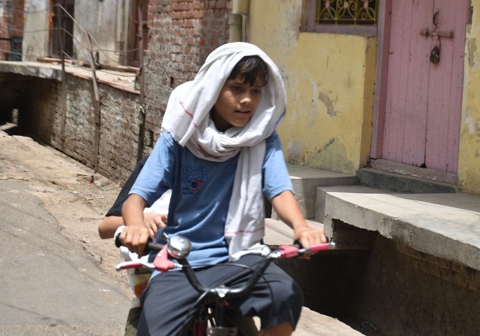 धूप से बचने को सिर ढंक कर जाता साइकिल सवार बालक। संवाद धूप से बचने को सिर ढंक कर जाता साइकिल सवार बालक। संवाद