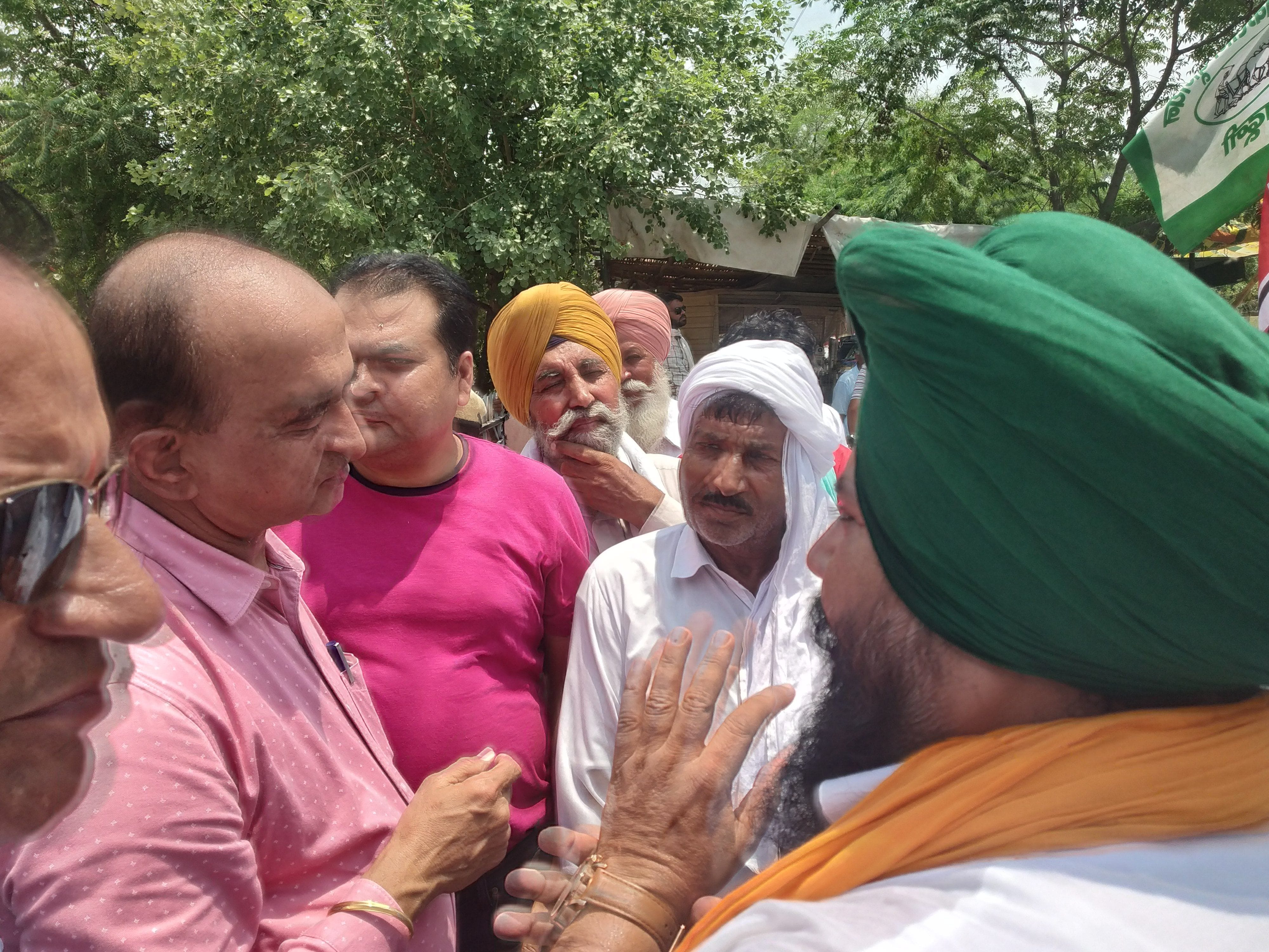 किसानों की ओर से धरना दिए जाने के बाद किसानों से बातचीत करते एक्सईएन।