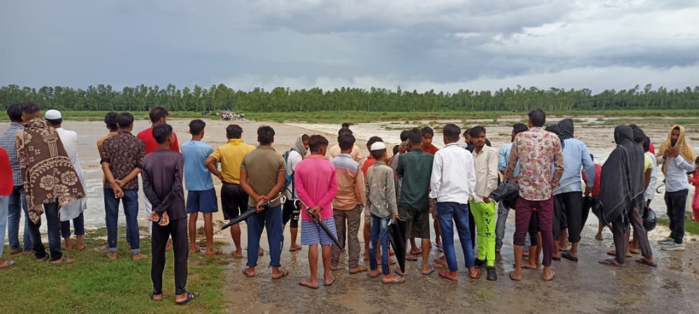 नदी किनारे पानी उतरने की बांट जोहते ग्रामीण नदी किनारे पानी उतरने की बांट जोहते ग्रामीण