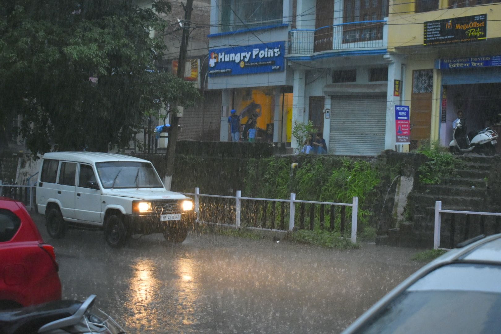 बिलासपुर में बारिश के बीच गुजरते वाहन।संवाद