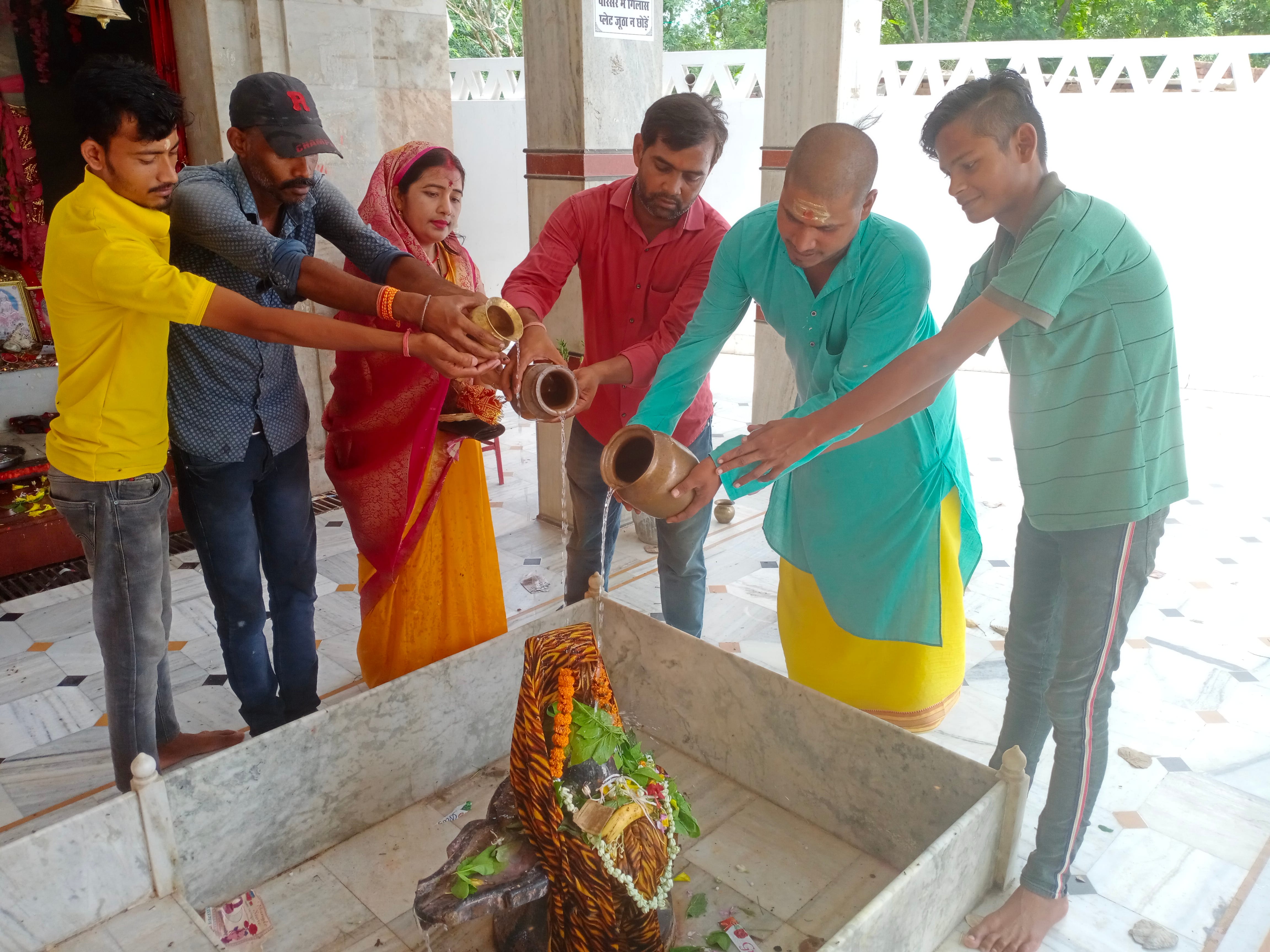 सावन के पहले दिन नगर के शीतला धाम स्थित शिवलिंग का जलाभिषेक करते पुजारी।संवाद सावन के पहले दिन नगर के शीतला धाम स्थित शिवलिंग का जलाभिषेक करते पुजारी।संवाद