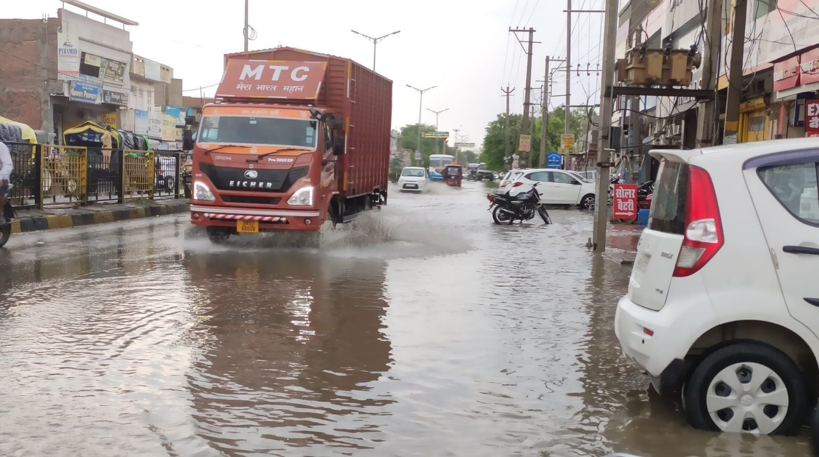 फतेहाबाद के जीटी रोड पर जलभराव के बीच से गुजरता ट्रक।