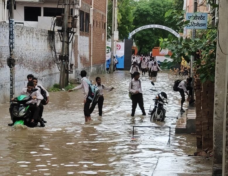 फतेहाबाद के राजकीय मॉडल संस्कृति स्कूल के बाहर हुए जलभराव से निकलते विद्यार्थी।