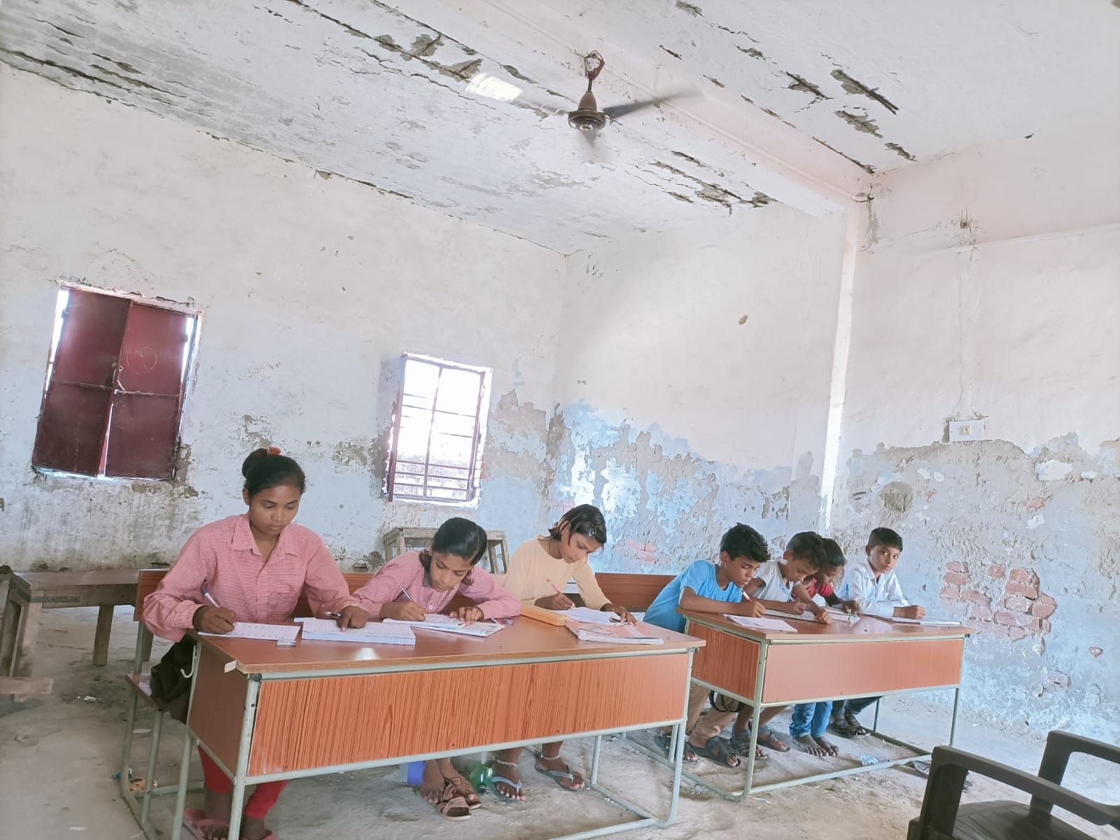 पुरवा भवानी स्कूल की छट का टूटा प्लास्टर नीचे बैठकर पढ़ाई करते बच्चे। संवाद पुरवा भवानी स्कूल की छट का टूटा प्लास्टर नीचे बैठकर पढ़ाई करते बच्चे। संवाद