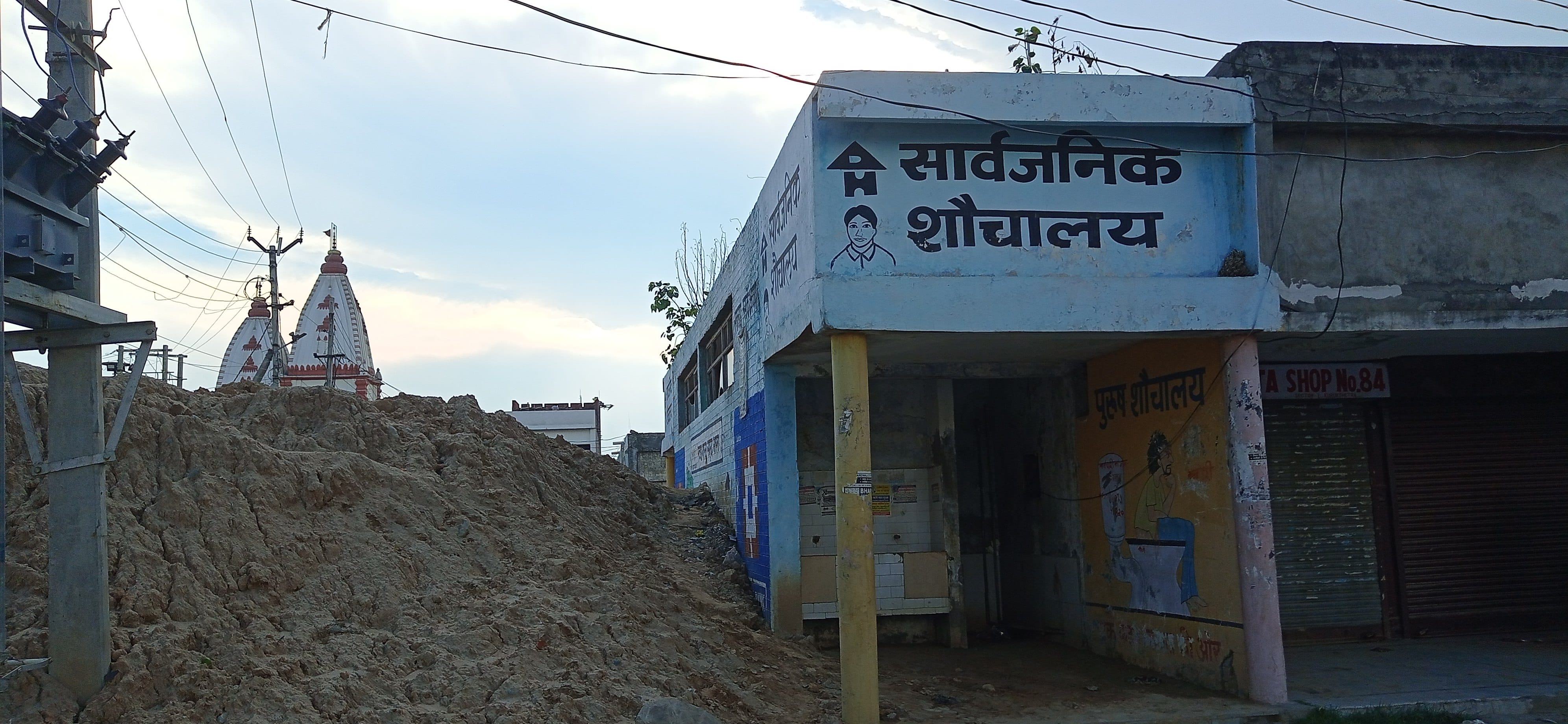सार्वजनिक शौचालय के पास लगा मिट्टी का ढेर।