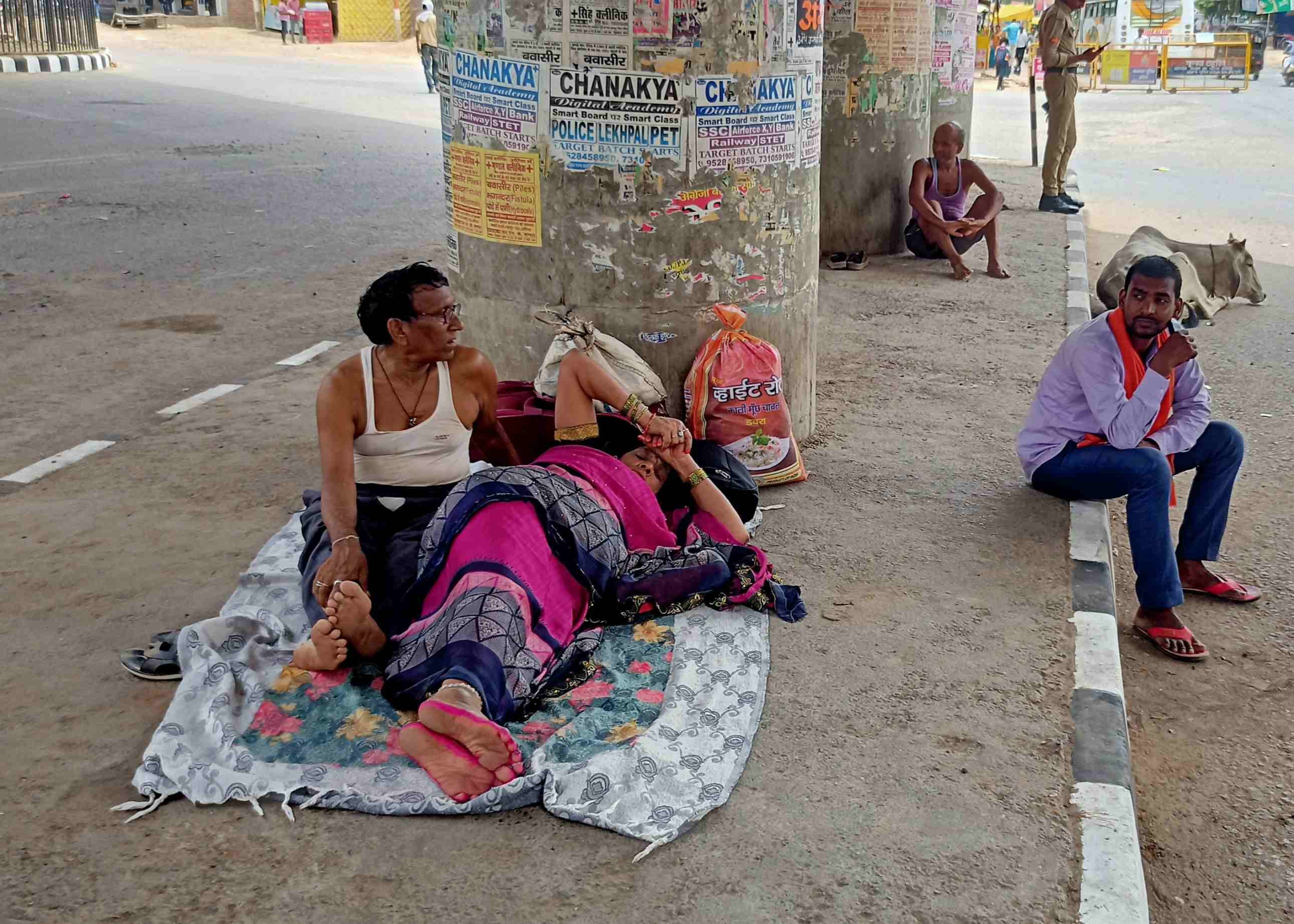  वाहन न मिलने से थक कर जालौन चौराहा के फुटपाथ पर लेटे दंपती। संवाद