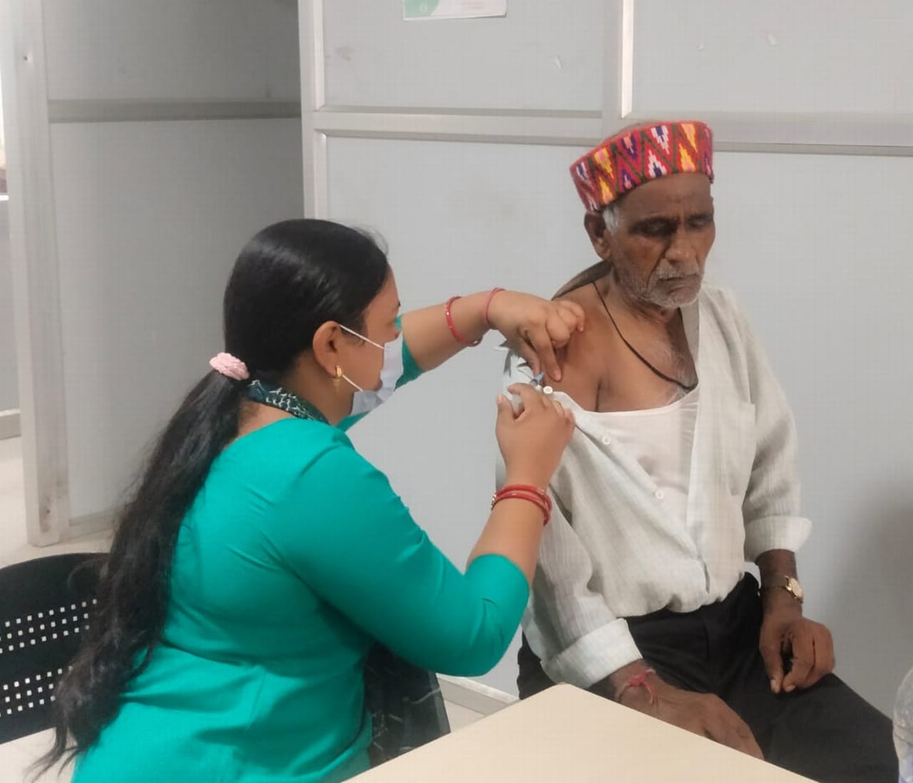 आयुष अस्पताल के टीकाकरण केंद्र में बुजुर्ग को बूस्टर डोज लगातीं स्वास्थ्य कर्मी। संवाद आयुष अस्पताल के टीकाकरण केंद्र में बुजुर्ग को बूस्टर डोज लगातीं स्वास्थ्य कर्मी। संवाद