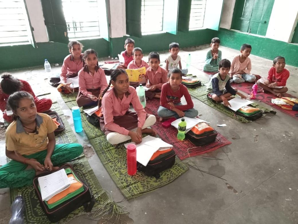 जर्जर स्कूल के एक कमरे में पढ़ते बच्चे। संवाद