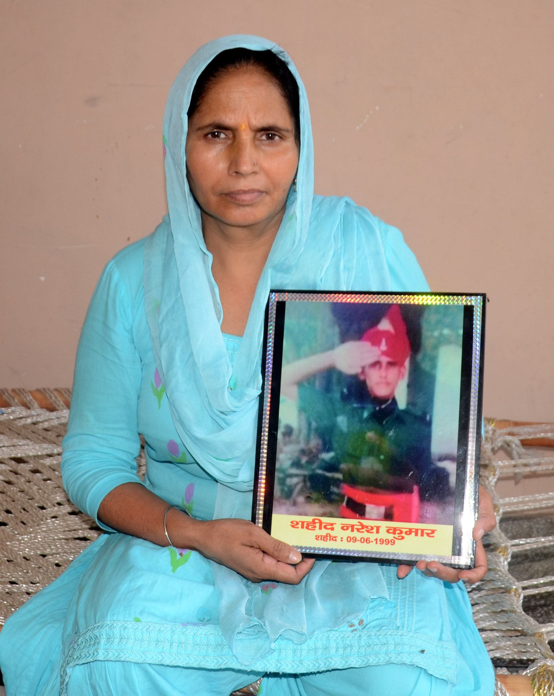 कारगिल में शहीद नरेश कुमार का फोटो लेकर बैठी पत्नी कल्पना। कारगिल में शहीद नरेश कुमार का फोटो लेकर बैठी पत्नी कल्पना।