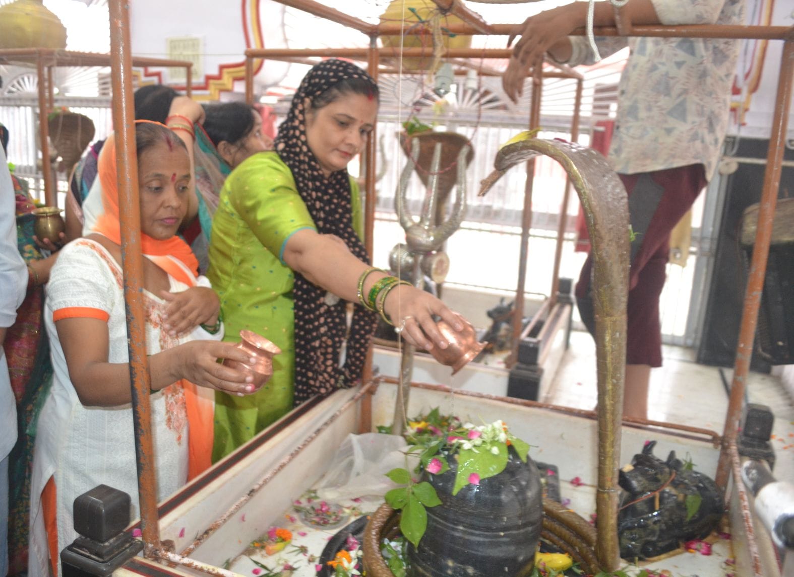 शहर के पांडवेश्वर नाथ मंदिर में जल चढ़ातीं महिलाएं। संवाद शहर के पांडवेश्वर नाथ मंदिर में जल चढ़ातीं महिलाएं। संवाद