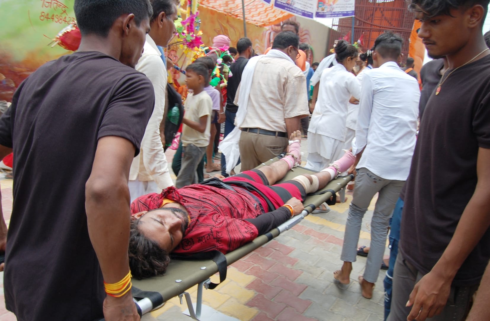 बागपत के पुरा महादेव मंदिर में धूप में बेहोश हुए कांवड़िये को स्ट्रेचर से ले जाते लोग। बागपत के पुरा महादेव मंदिर में धूप में बेहोश हुए कांवड़िये को स्ट्रेचर से ले जाते लोग।