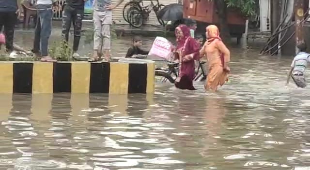 सरसावा में सड़क पर भरे पानी से गुजरती महिलाएं सरसावा में सड़क पर भरे पानी से गुजरती महिलाएं