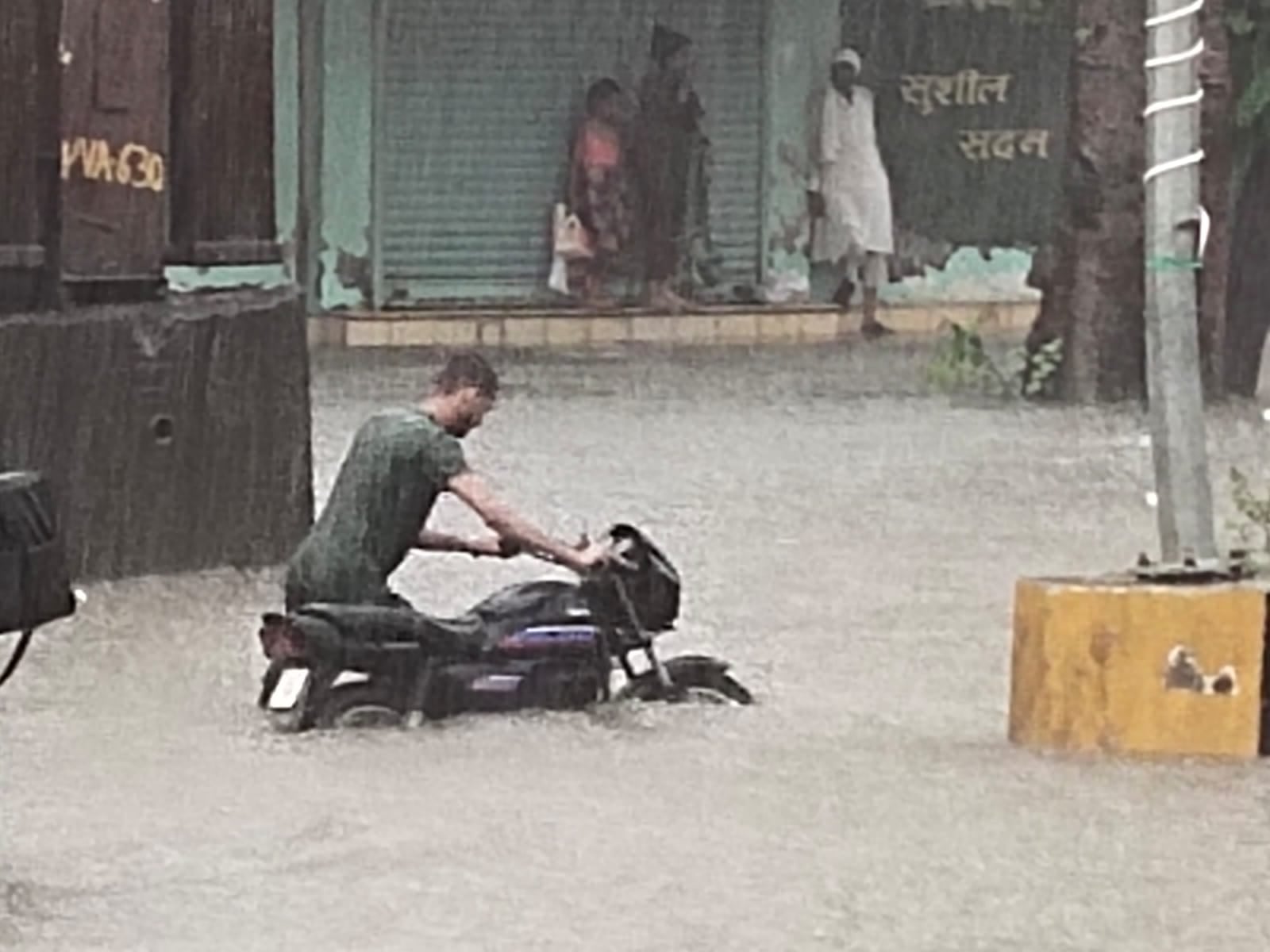 सरसावा में सड़क पर भरे पानी से पैदल गुजरता बाइक सवार सरसावा में सड़क पर भरे पानी से पैदल गुजरता बाइक सवार