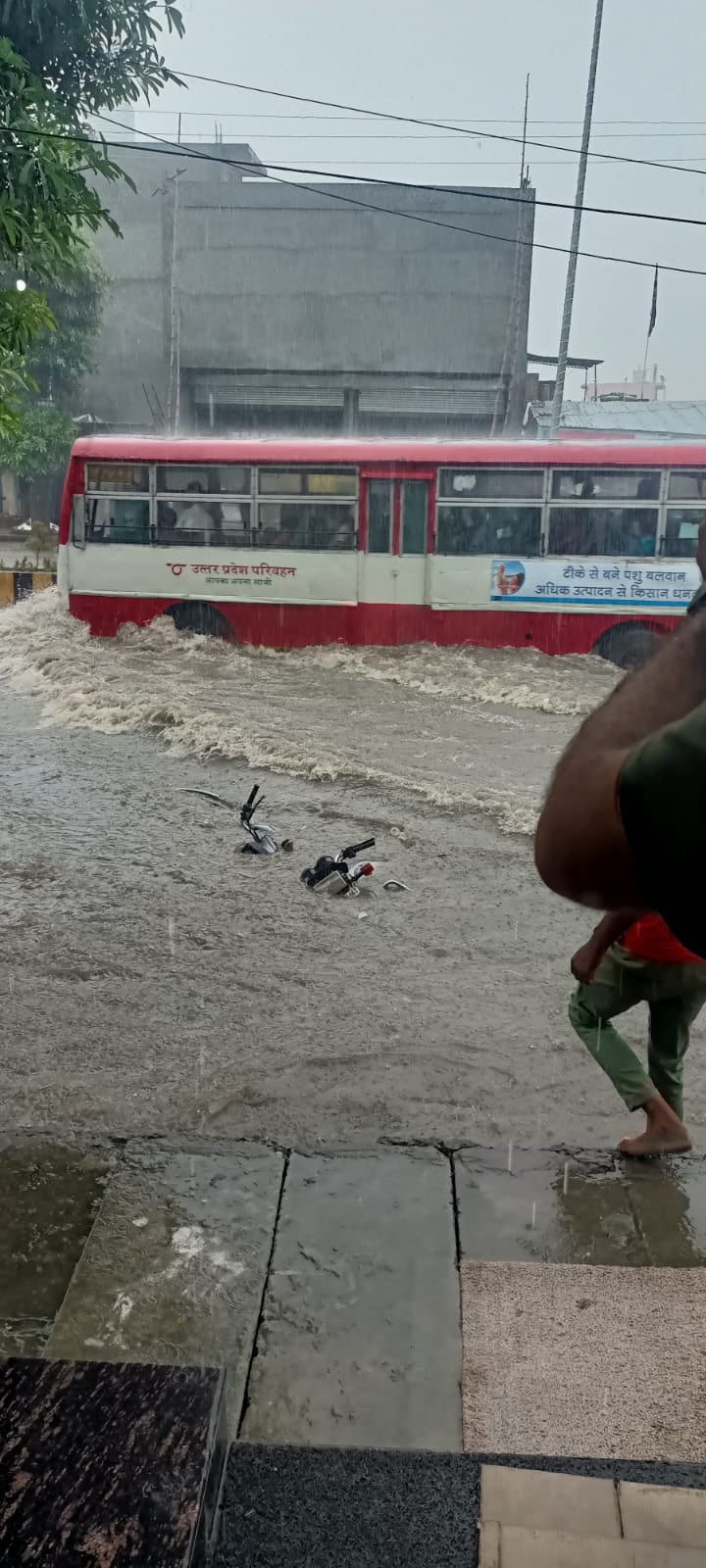 सड़क पर भरे पानी से गुजरती रोडवेज और डूबी बाइक सड़क पर भरे पानी से गुजरती रोडवेज और डूबी बाइक