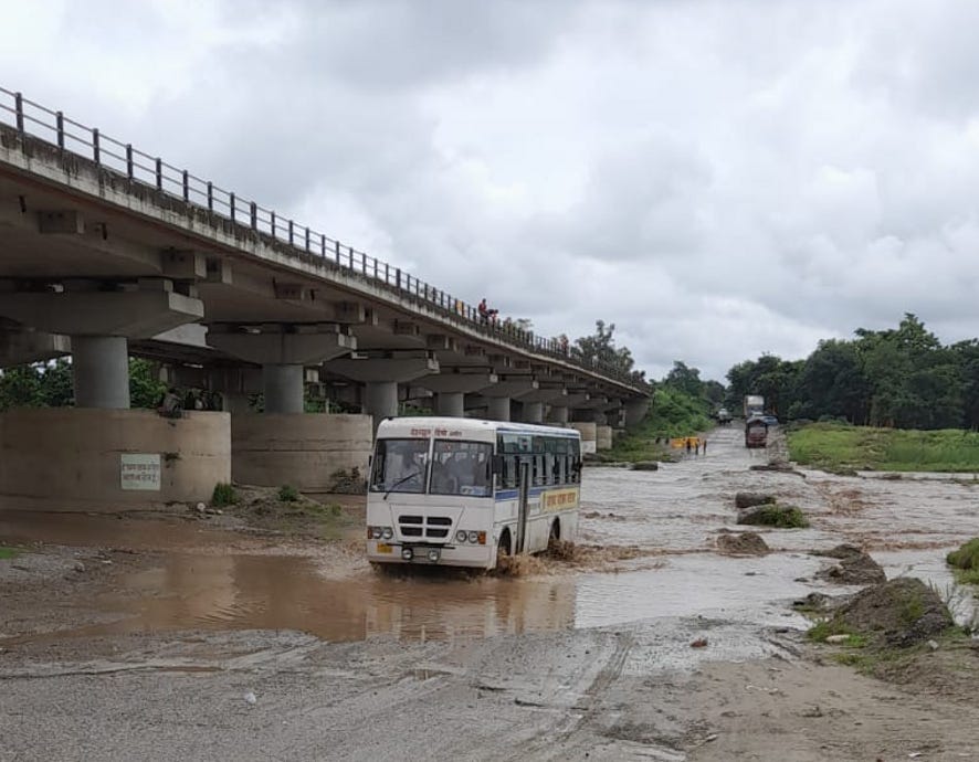 भागूवाला के कोटावाली नदी रपटे का जलस्तर सामान्य होने पर गुजरते वाहन।