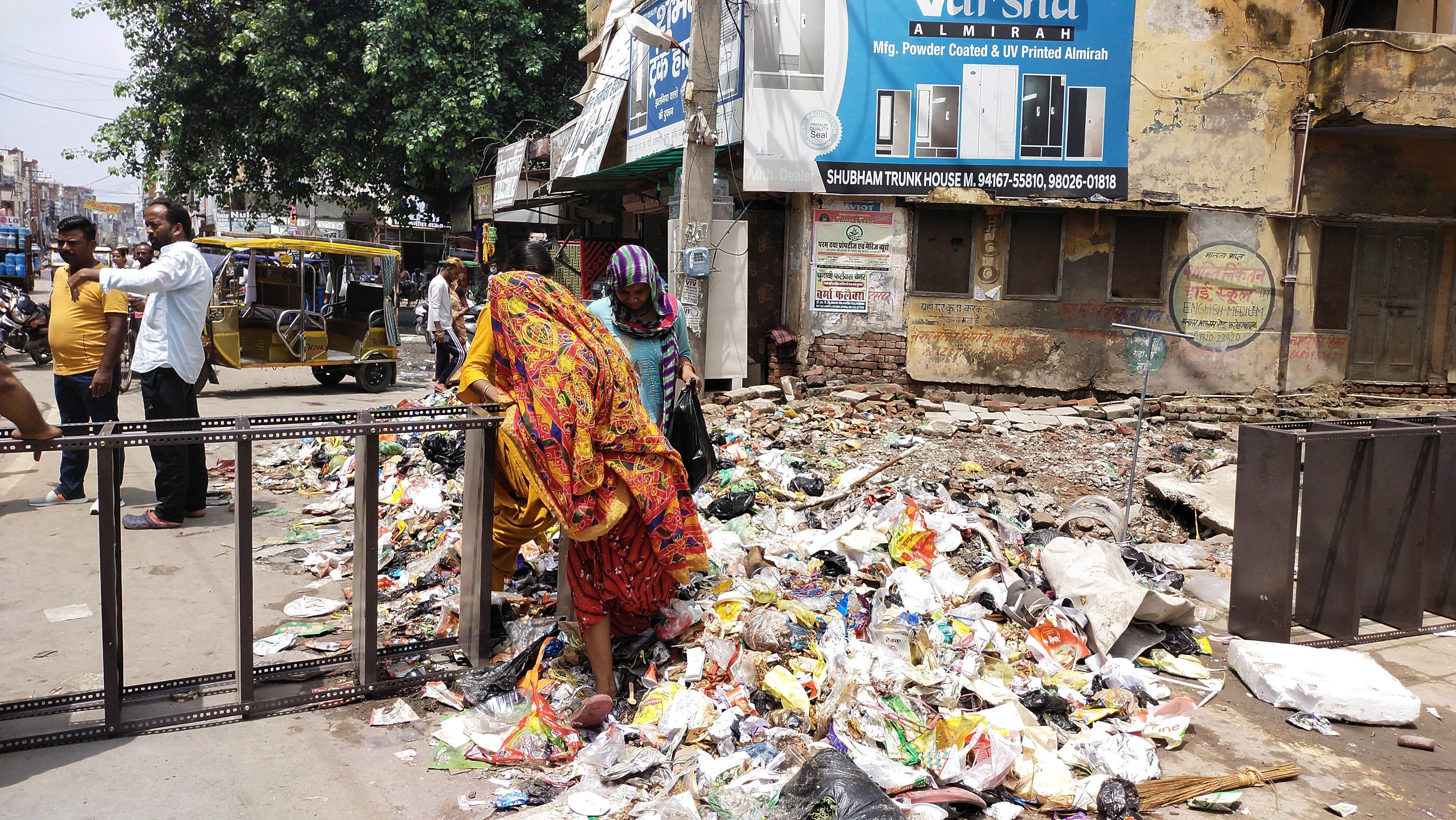 फतेहाबाद के जवाहर चौक में कचरे के ऊपर से गुजरती हुई महिलाएं