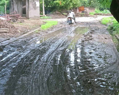 पूरनपुर के गांव खाता में सड़क पर कीचड़ से निकलते लोग। संवाद पूरनपुर के गांव खाता में सड़क पर कीचड़ से निकलते लोग। संवाद