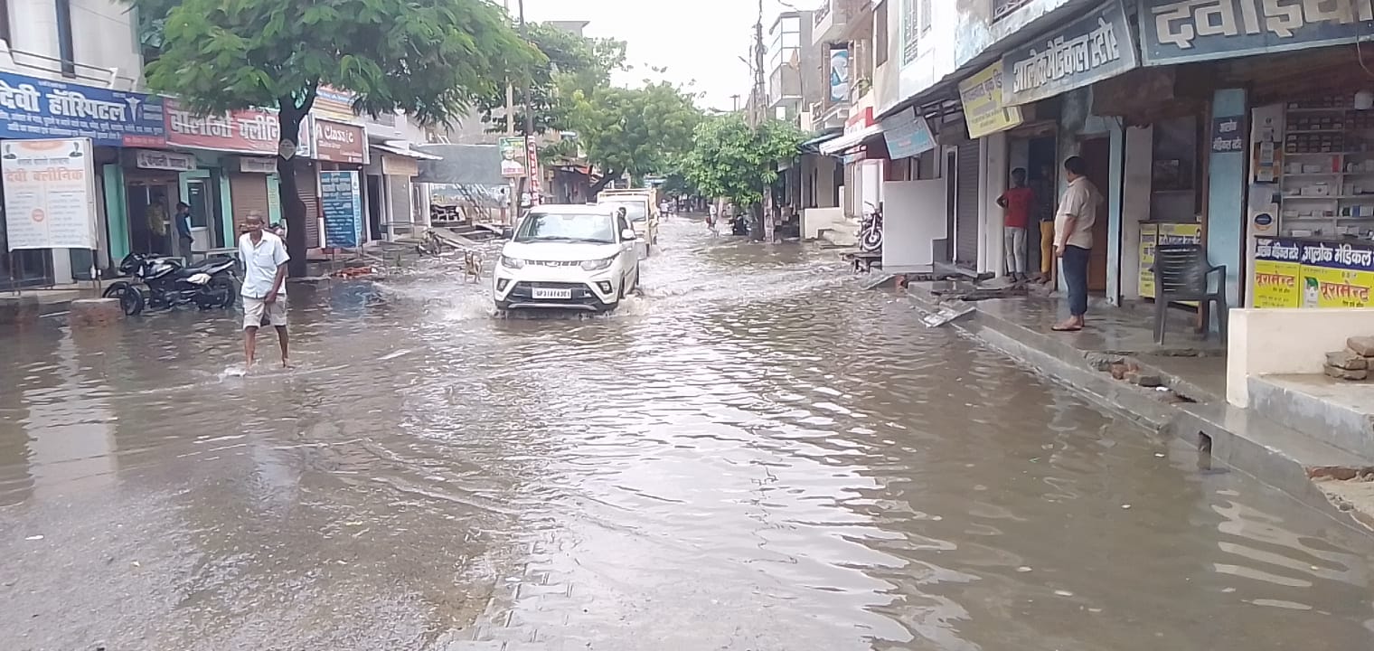 गोला के सिनेमा रोड पर जलभराव से निकलते वाहन। गोला के सिनेमा रोड पर जलभराव से निकलते वाहन।