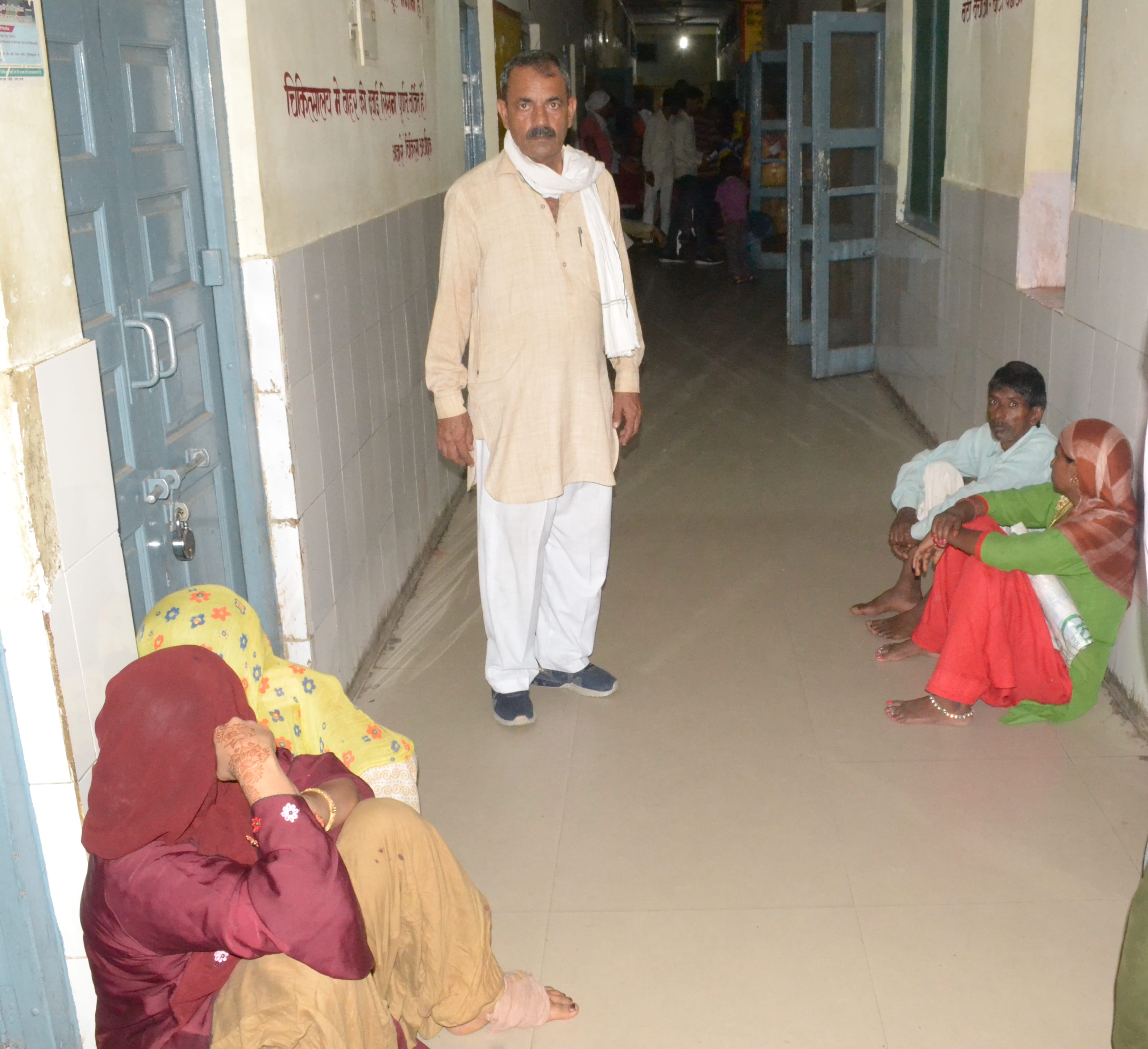 शामली सीएचसी में एक्सरे रूम के बाहर फर्श पर बैठ कर बिजली आने का इंतजार करते मरीज।