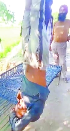 पेड़ से उलटा लटकाया गया मानसिक मंदित। पेड़ से उलटा लटकाया गया मानसिक मंदित।