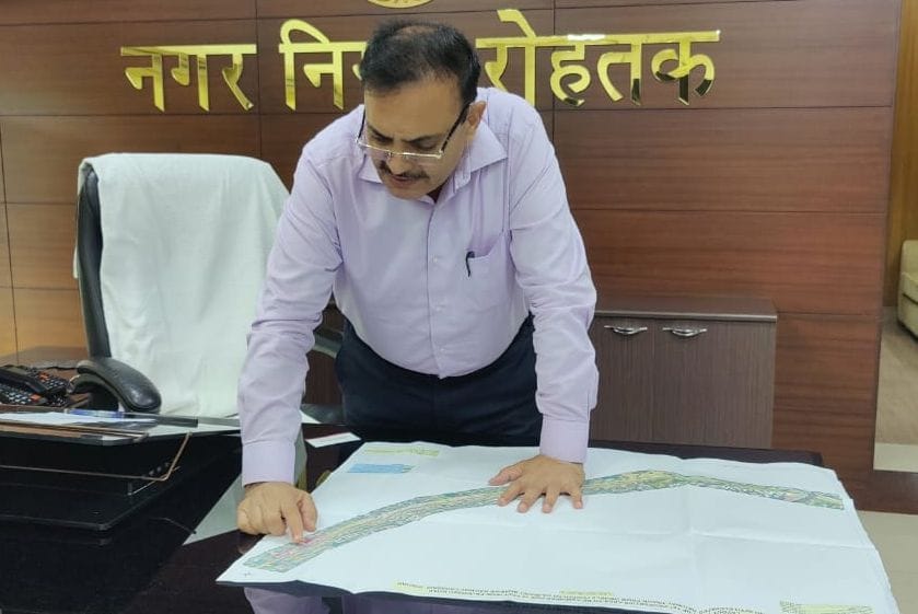 रेलवे एलिवेटेड पुल के साथ बनने वाली सड़क का नक्शा देखते निगम आयुक्त डॉ. नरहरि सिंह बागड़। अमर उजा?