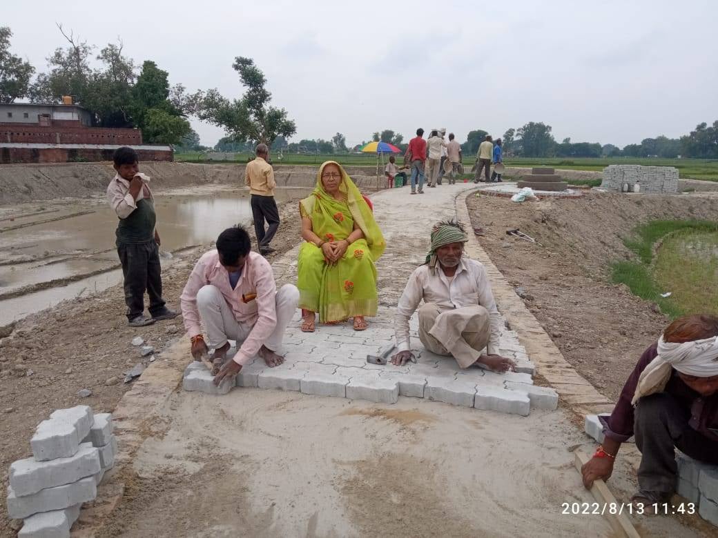 सरोवर के चारों ओर इंटरलॉकिंग करते मजदूर। सरोवर के चारों ओर इंटरलॉकिंग करते मजदूर।