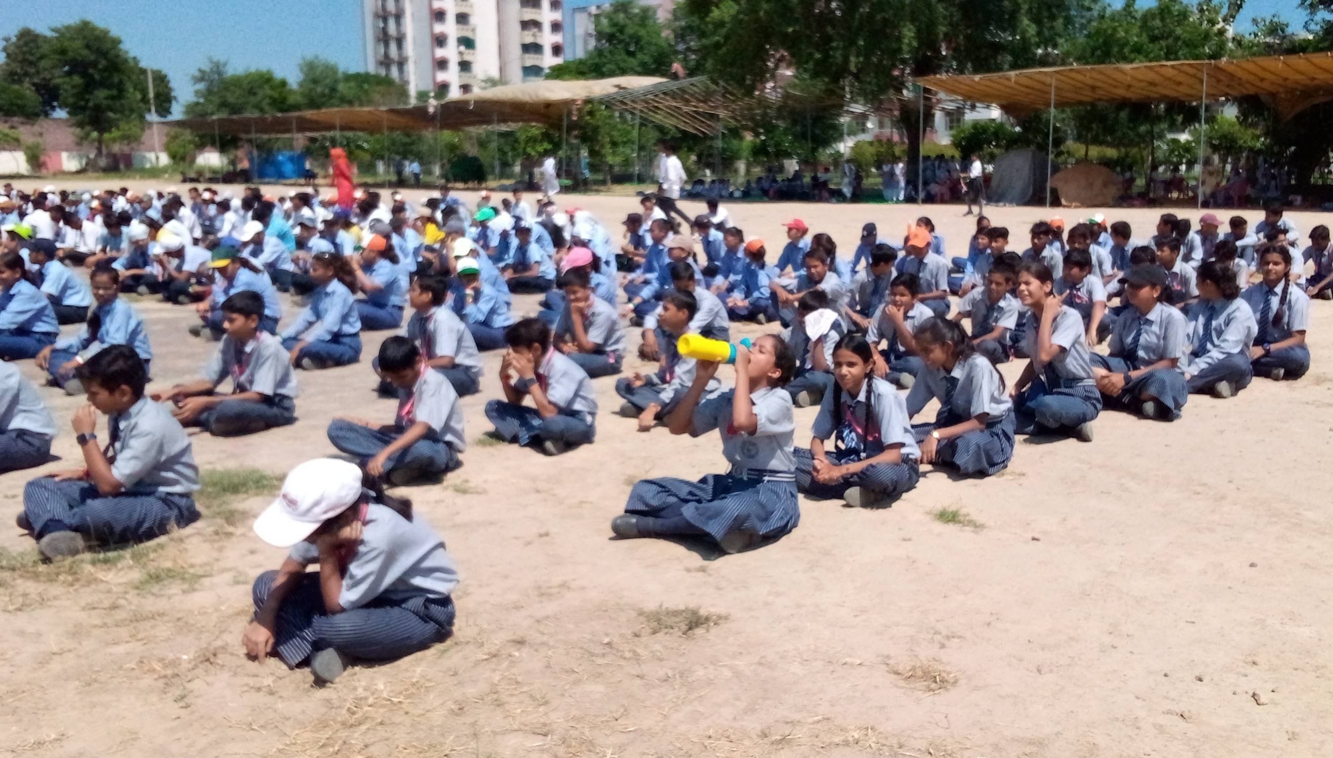 तपती धूप में पीटी की रिहर्सल के दौरान पानी पीती छात्रा। संवाद तपती धूप में पीटी की रिहर्सल के दौरान पानी पीती छात्रा। संवाद