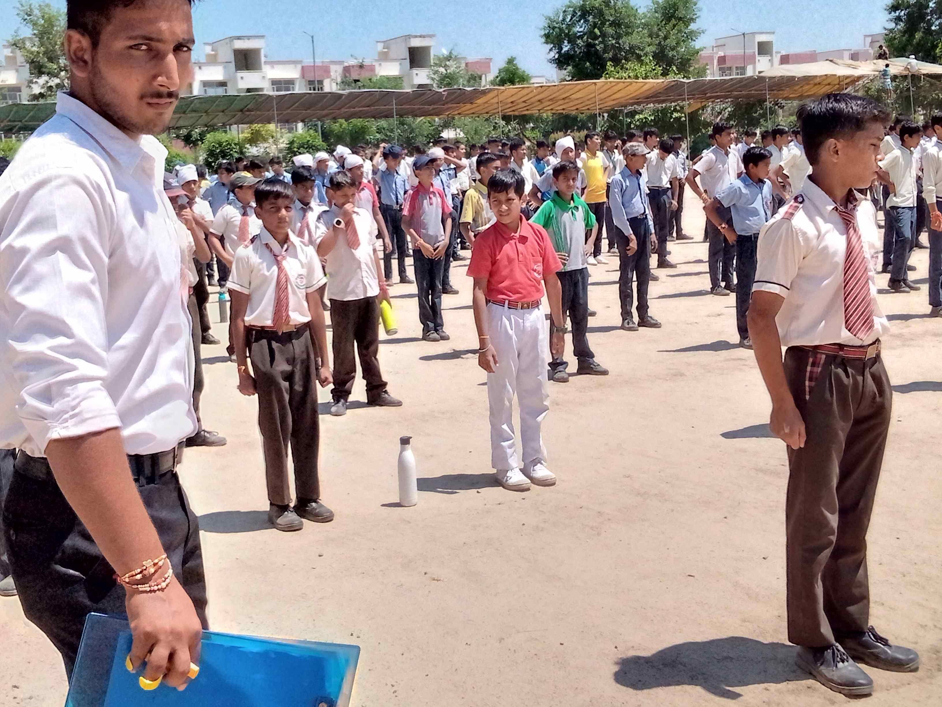 धूप में अपने साथ पानी की बोतल लेकर रिहर्सल करते विद्यार्थी। संवाद धूप में अपने साथ पानी की बोतल लेकर रिहर्सल करते विद्यार्थी। संवाद