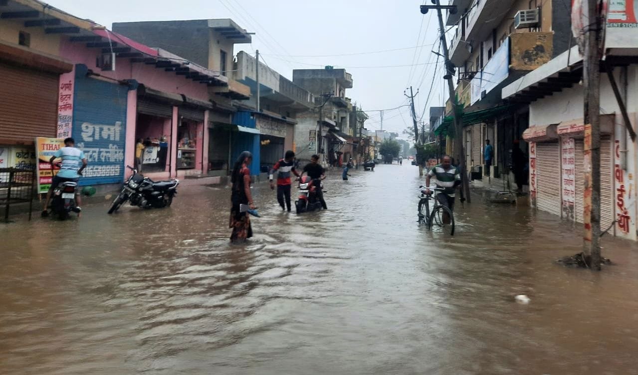   कालूपुर में जलमग्न सड़क पर बंद हुई बाइक को धक्का मारकर ले जाते युवक। संवाद