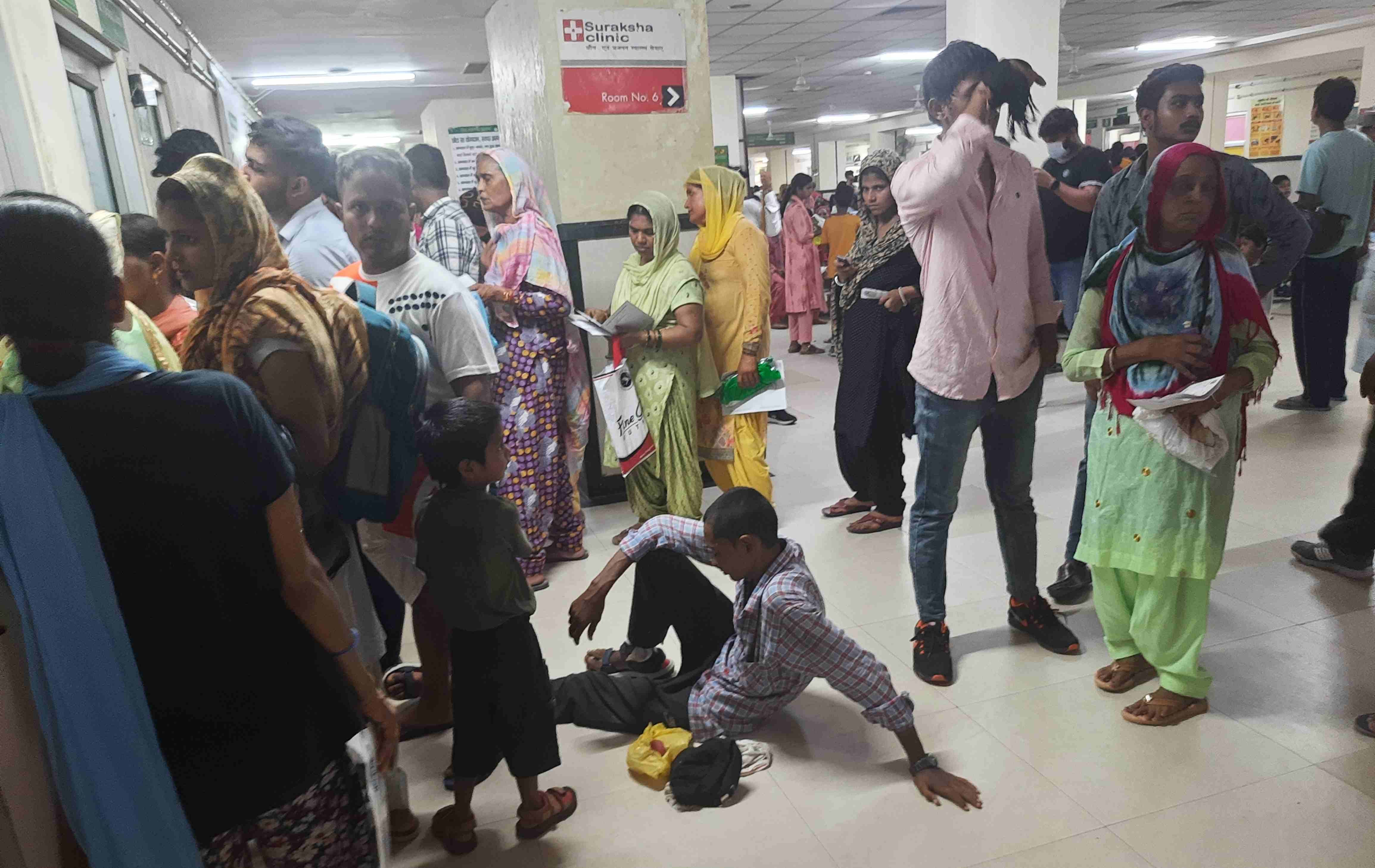  नागरिक अस्पताल में हड्डी रोग विशेषज्ञ के कमरे के बाहर लाइन में फर्श पर बैठा मरीज। संवाद
