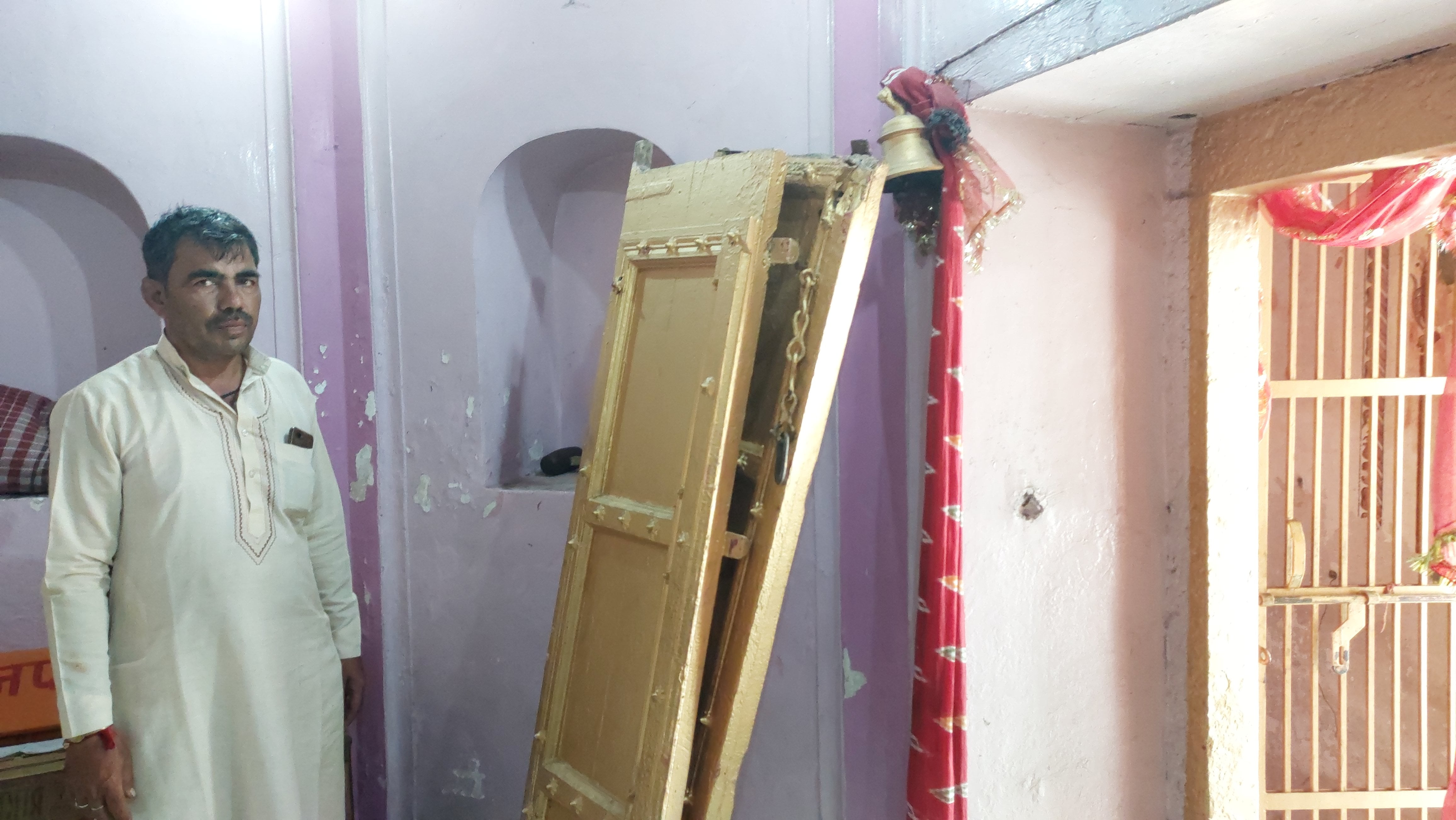 कैराना के प्राचीन बाला सुंदरी मंदिर के उखाड़े हुए गेट दिखाता पुजारी।