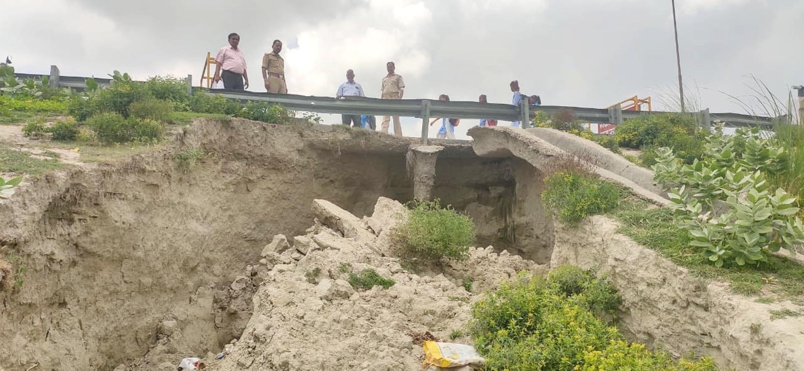 कछला में पुल के धंस गए संपर्क मार्ग को देखते नगर पंचायत और पुलिस कर्मी। संवाद