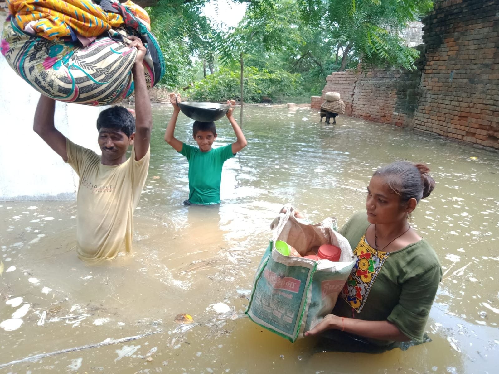 इटावा में बाढ़ ...नेकराम अपना परिवार सामान लेकर सुरक्षित स्थान की ओर जाता हुआ। संवाद