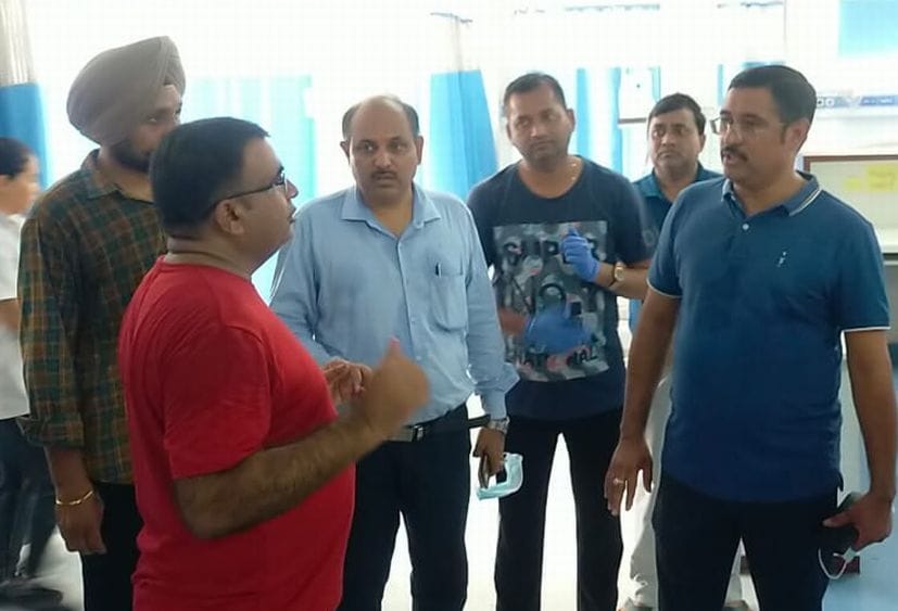 रुद्रपुर जिला अस्पताल में डॉक्टरों से बात करते डीएम।