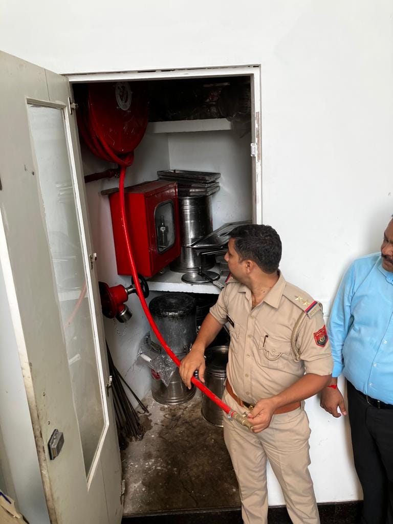 होटल के अंदर किचन में लगी फायर लाइन को चेक करते दमकल अधिकारी। संवाद