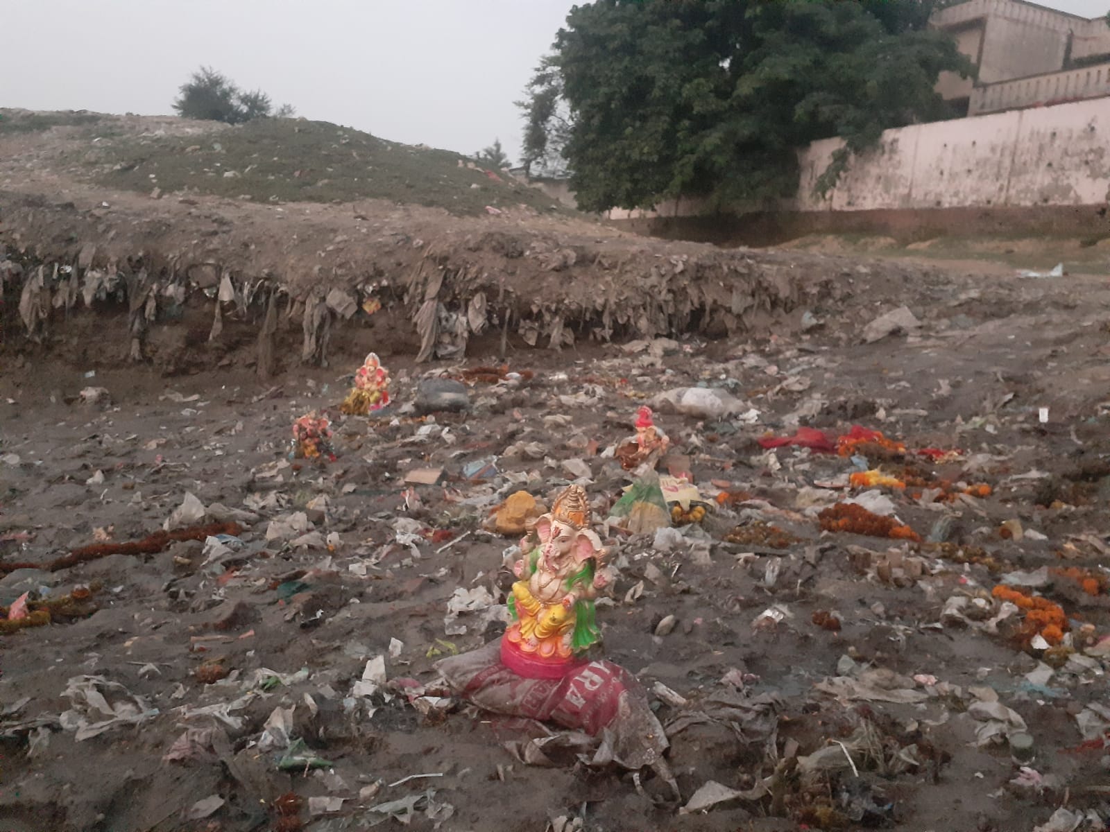 ब्रह्मचारी घाट के पास कूड़े के ढेर में पड़ी मूर्तियां। संवाद