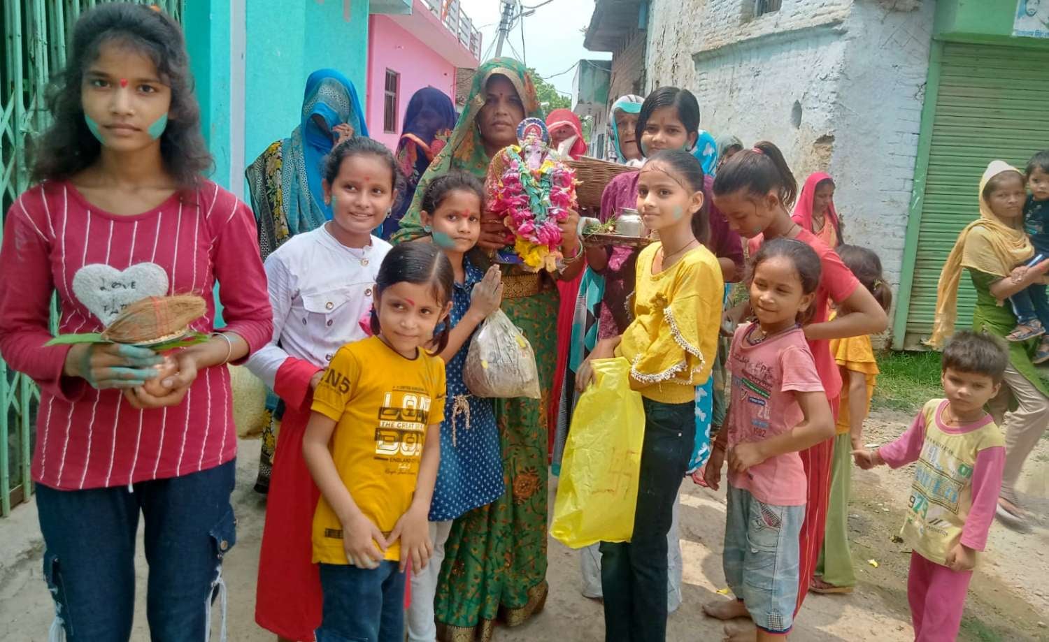 खरेला में घर पर स्थापित प्रतिमा का विसर्जन करनें जातीं महिलाएं व बच्चें।