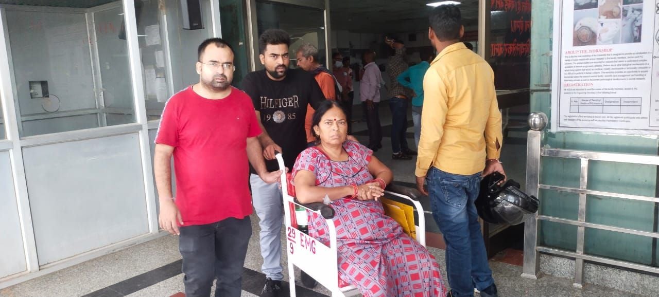 व्हीलचेयर से अपनी मां को जनरल वार्ड में ले जाते अमित। संवाद