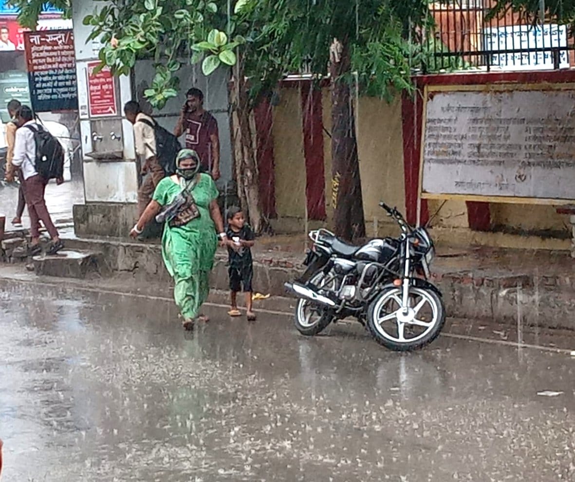बागपत कोर्ट रोड पर बारिश के बीच जाते महिला व छात्र बागपत कोर्ट रोड पर बारिश के बीच जाते महिला व छात्र