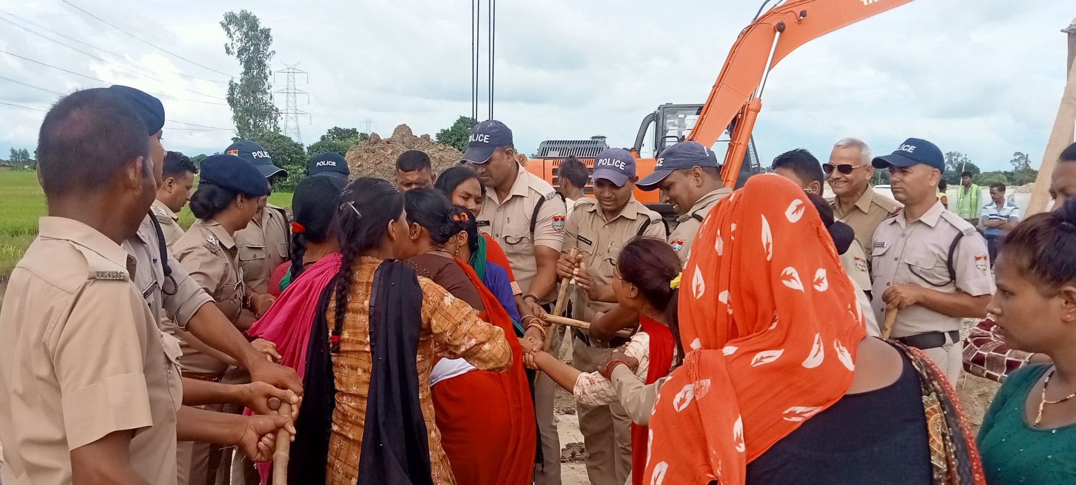 खटीमा में बाईपास में ह्यूम पाइप डालने का विरोध करती महिलाओं को रोकती पुलिस टीम। संवाद
