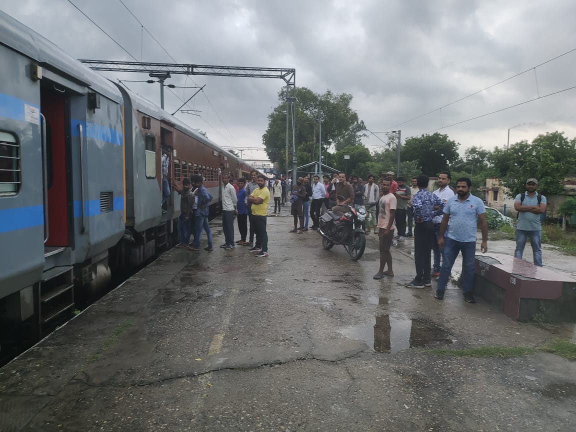 हापुड़ः आग लगने के कारण रेलवे स्टेशन पर खड़ी ट्रेन के बाहर प्लेटफार्म पर खड़े यात्री। संवाद
