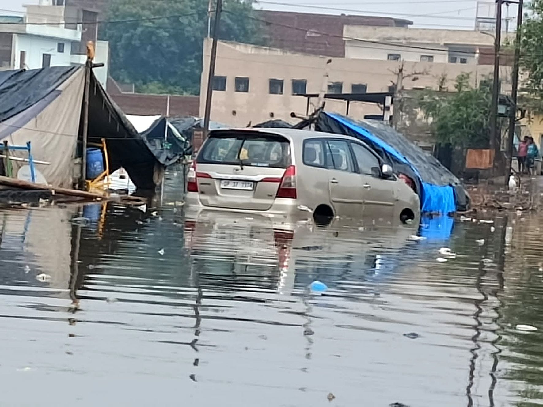 शाहजमाल ईदगाह पर बारिश के बाद जलभराव में फंसी कार।