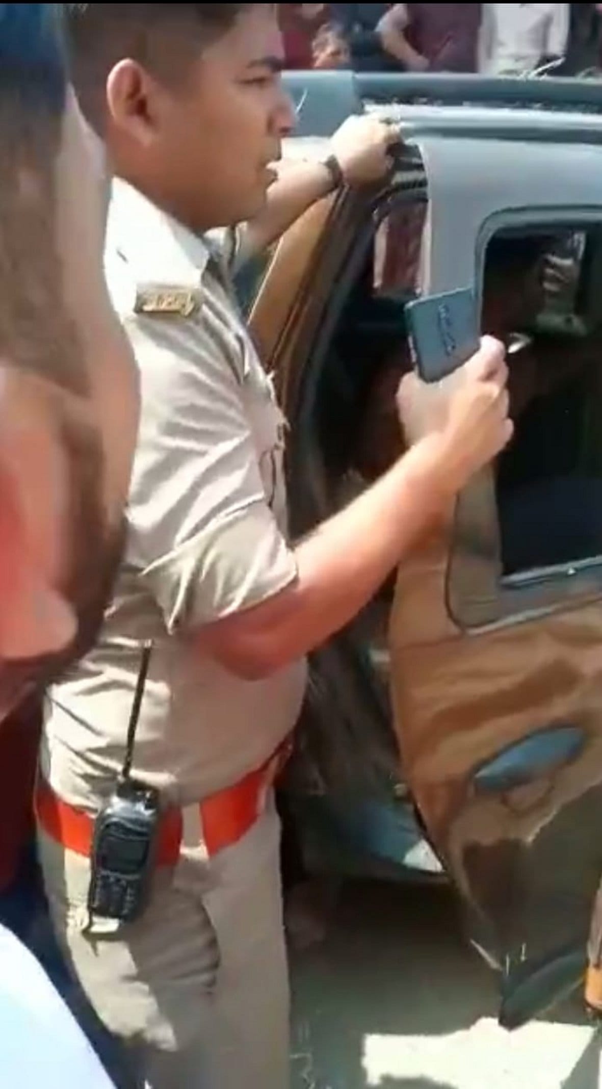 कार में बैठे युवकों की धुनाई कर रहे लोगो को समझाता पुलिसकर्मी कार में बैठे युवकों की धुनाई कर रहे लोगो को समझाता पुलिसकर्मी