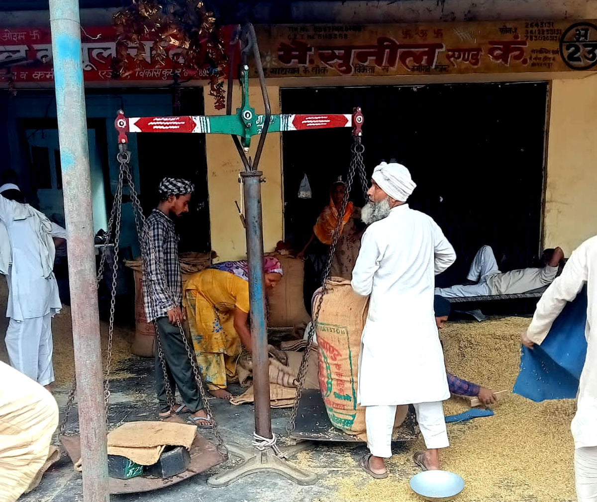 मंडी में धान की तुलाई करते कर्मी मंडी में धान की तुलाई करते कर्मी