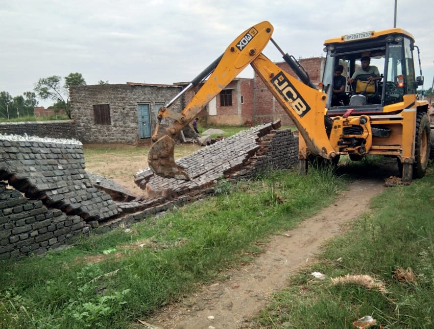 नजीबाबाद के आजाद चौक क्षेत्र में अवैध निर्माण गिराती जेसीबी।